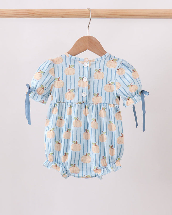 A baby romper in light blue with vertical stripes and a pumpkin print, hanging on a wooden hanger against a plain light background.