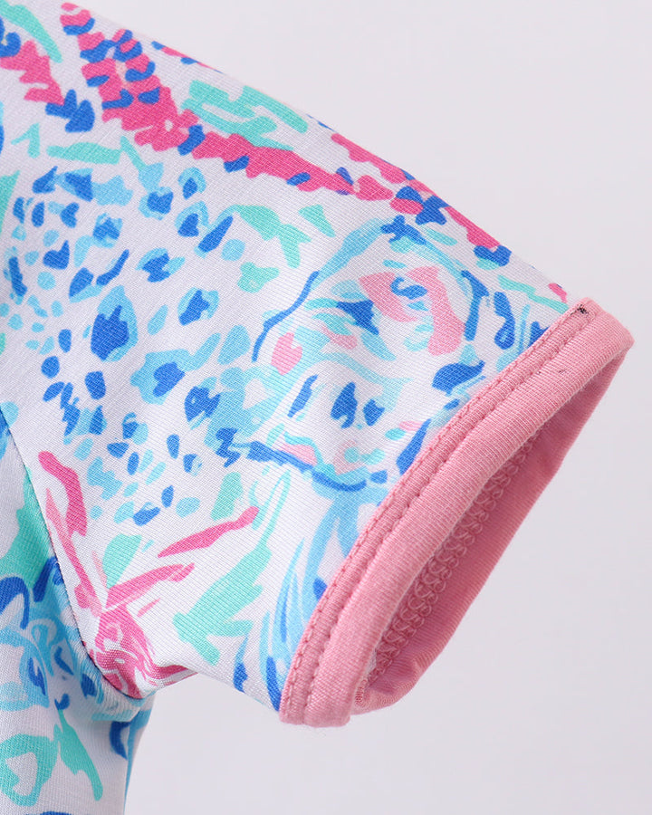 Colorful outfit with pink waistband on a light gray background