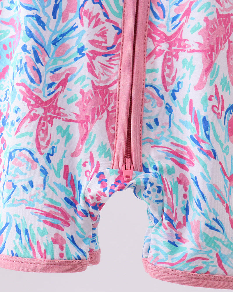 Colorful floral-patterned garment with a pink zipper on a light background