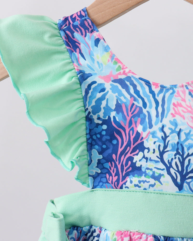 Mint green top with colorful coral reef pattern on a hanger