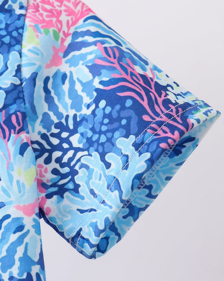 Colorful patterned fabric with blue, pink, and green design on a white background