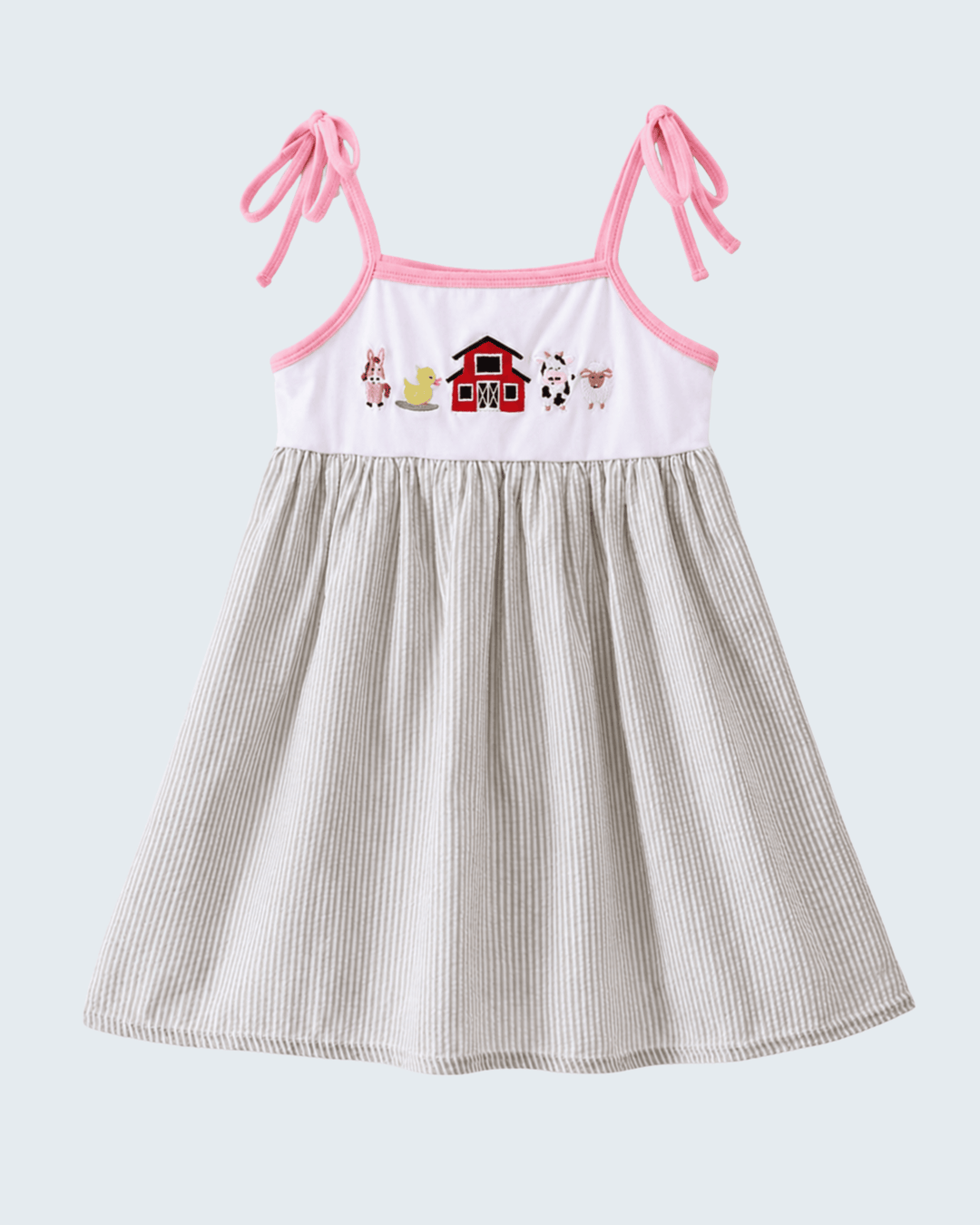 Children's dress with pink straps and farm-themed design on a white background
