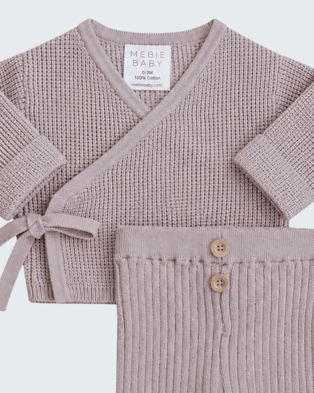A baby knit two-piece set in dusty mauve, featuring a long-sleeve wrap cardigan with a tie detail and matching ribbed pants with two wooden buttons, from the brand MEBIE BABY.