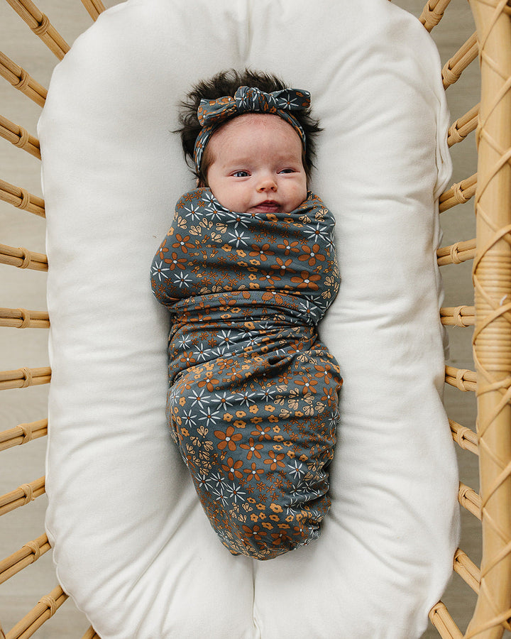 Dark blue floral knotted head wrap with wide bow, worn on a baby’s head