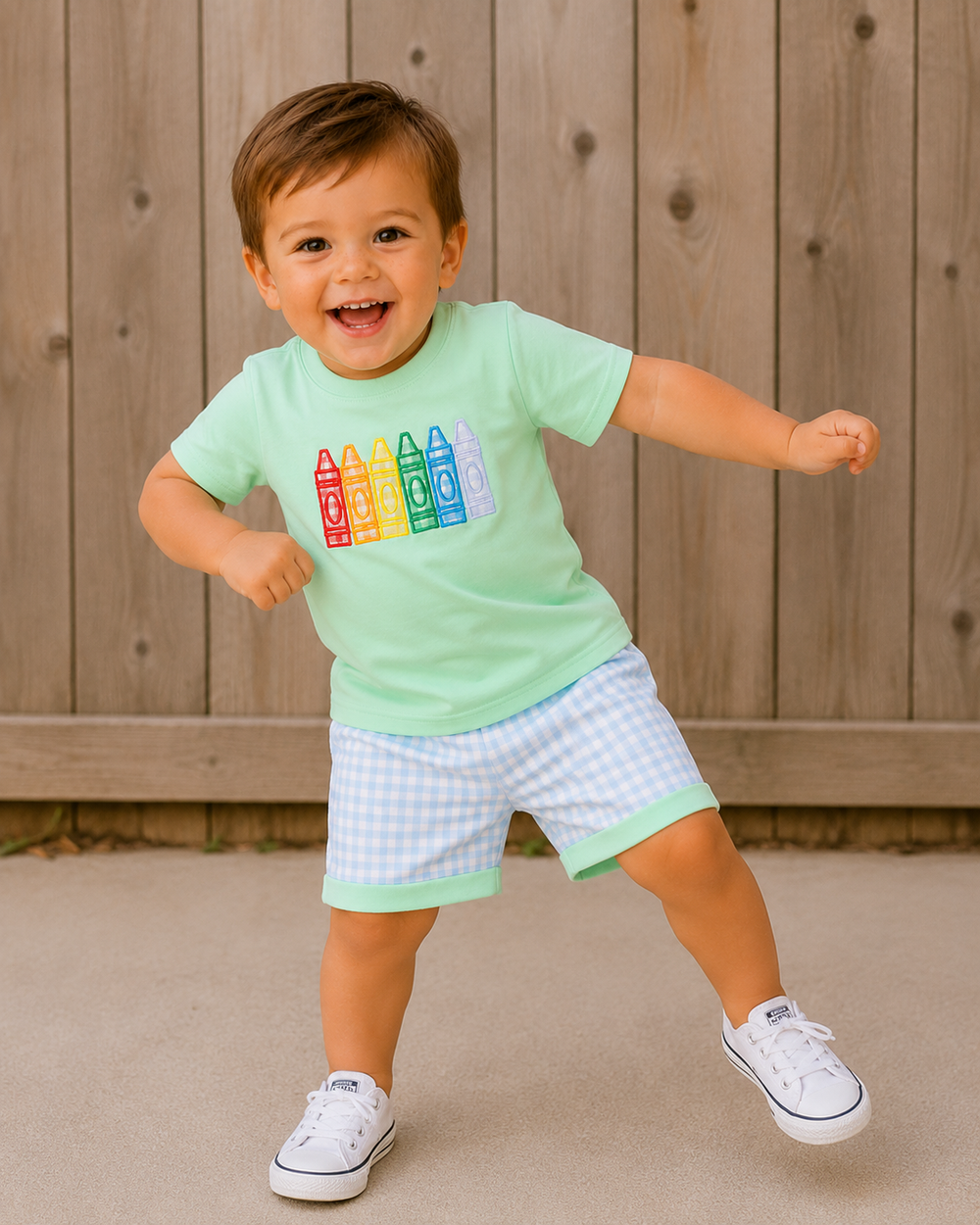 Young boy dancing in front of a wooden fence