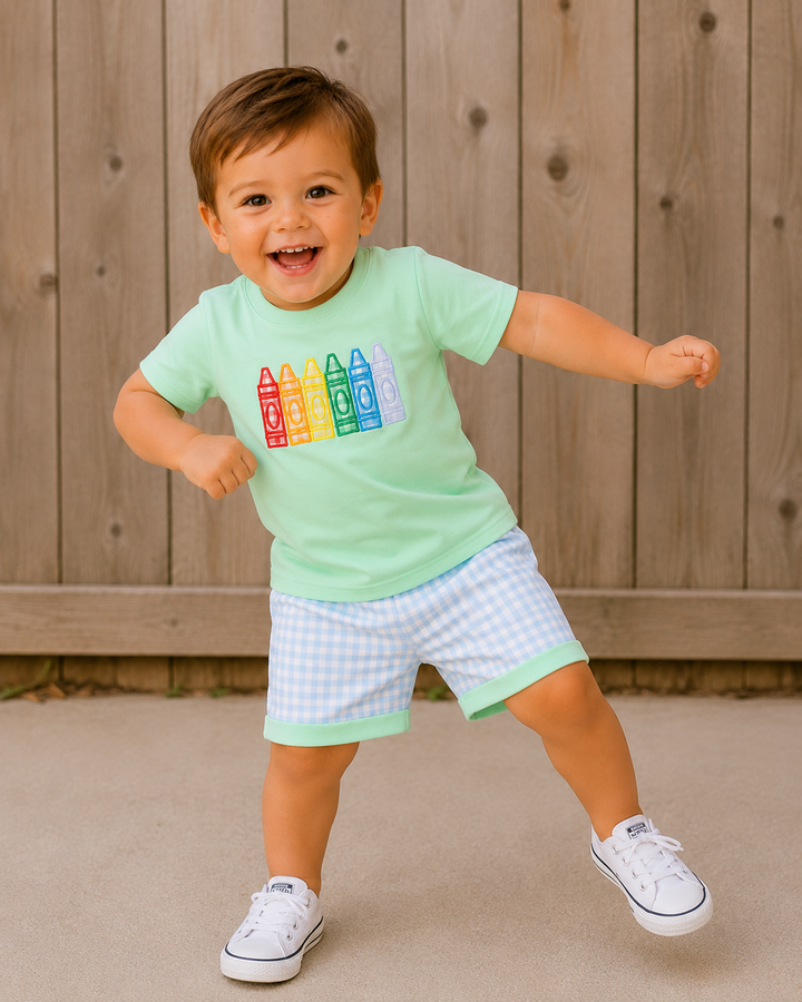 Young boy dancing in front of a wooden fence