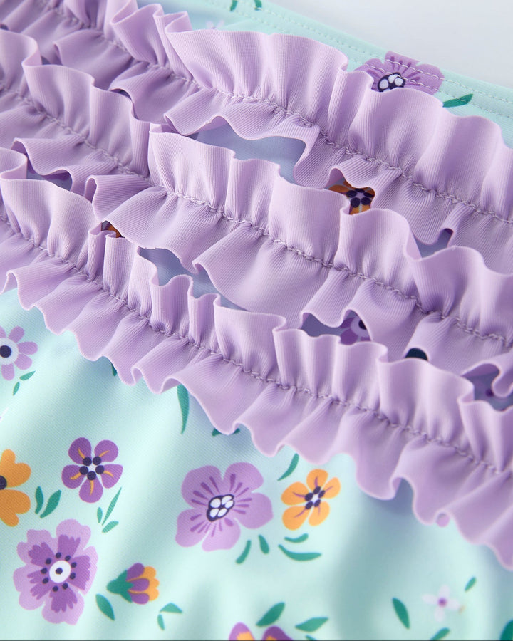 Close-up of a purple ruffled trim on a floral background