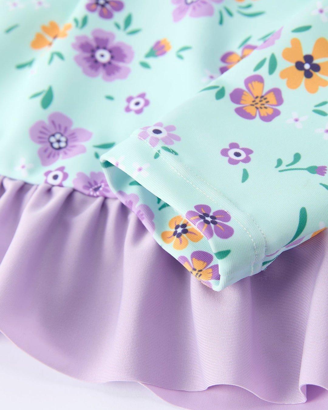 Close-up of fabric with floral pattern and purple ruffle