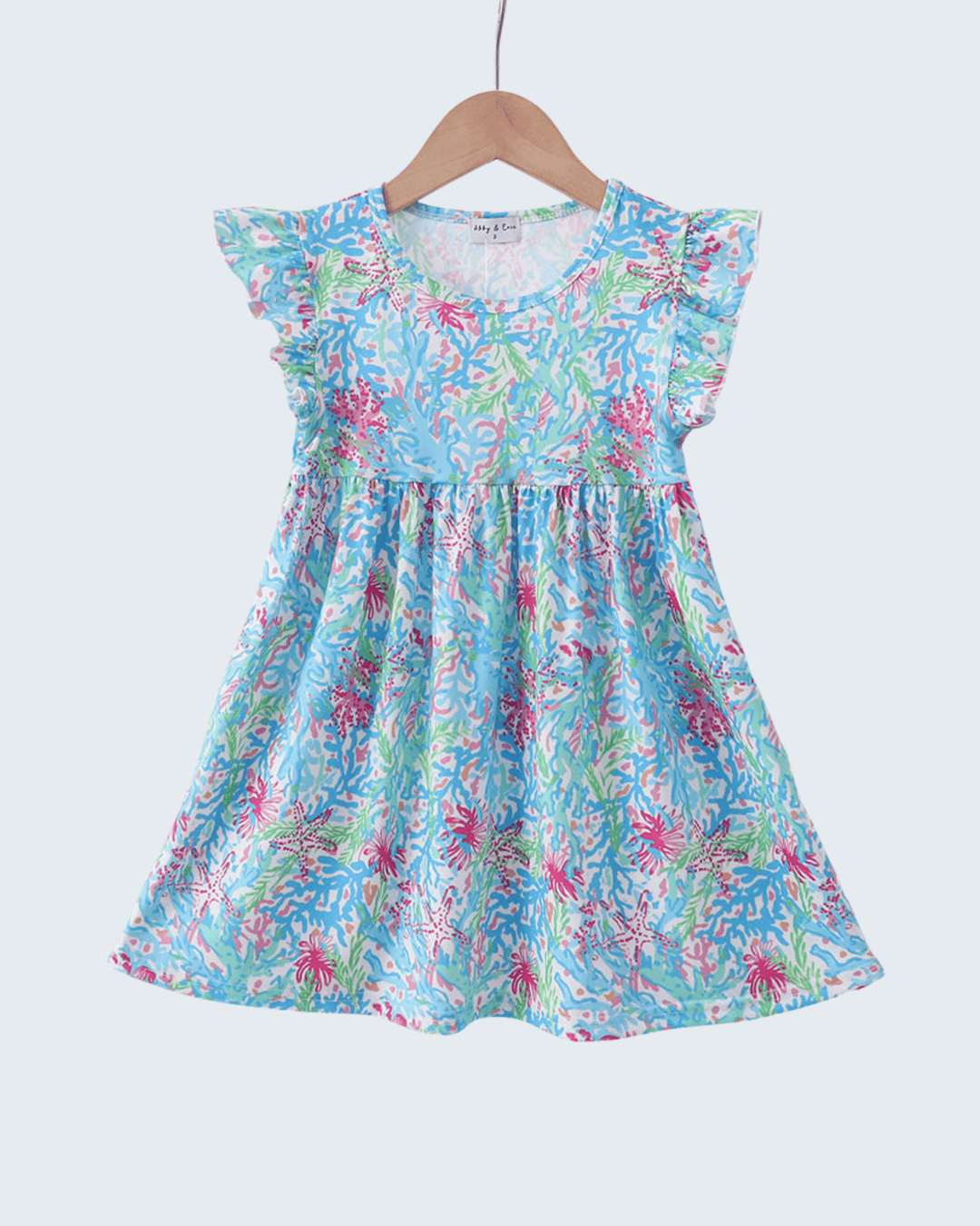 Floral dress on a hanger against a white background