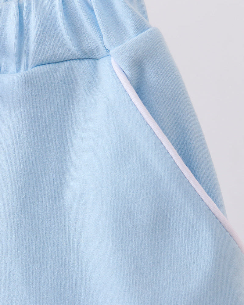Light blue skort close-up with angled side seam and drawstring tie