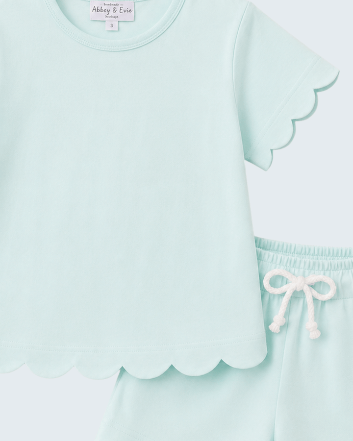 Light blue short set with scalloped edges and a matching skirt on a white background