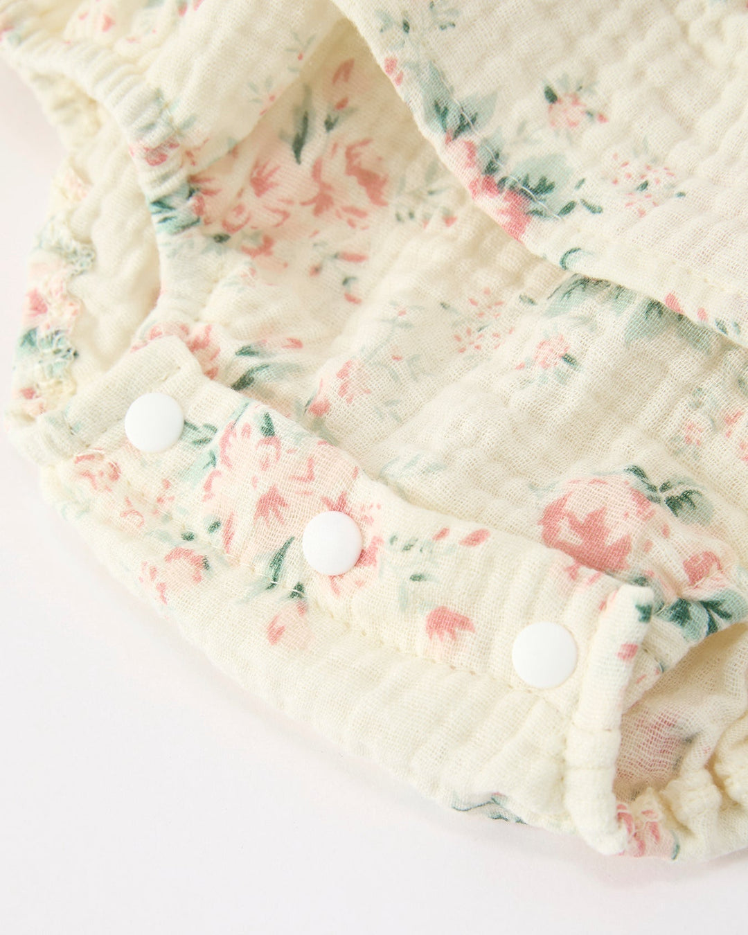 Floral-patterned fabric with white buttons on a light background
