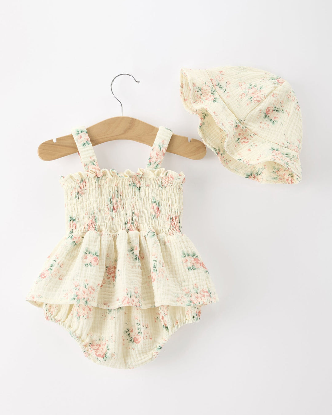 Floral baby romper with matching hat on a white background