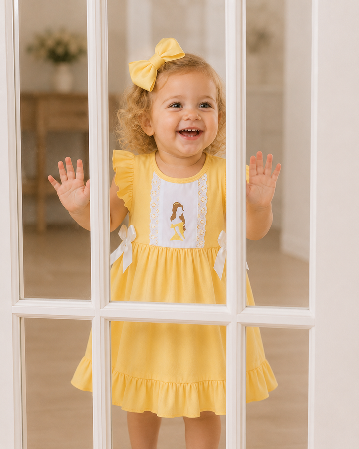 Toddler in a yellow princess dress in looking through glass door