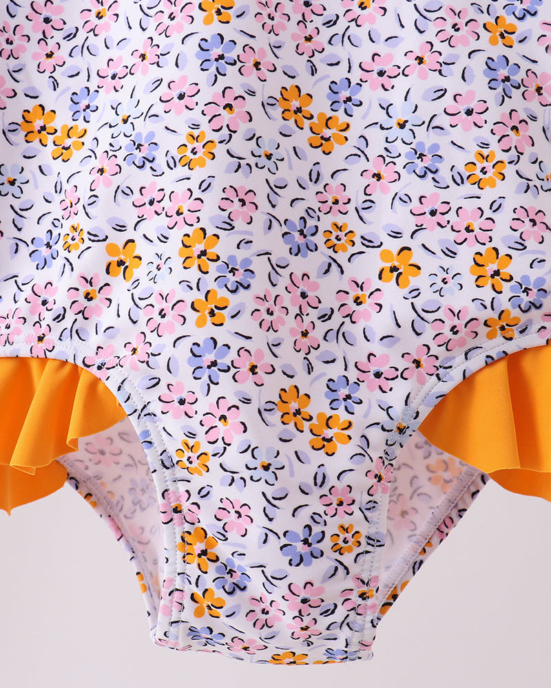 Floral-patterned swimsuit with orange ruffles on a light gray background