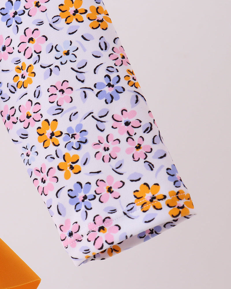Floral-patterned fabric with pink, orange, and purple flowers on a light background