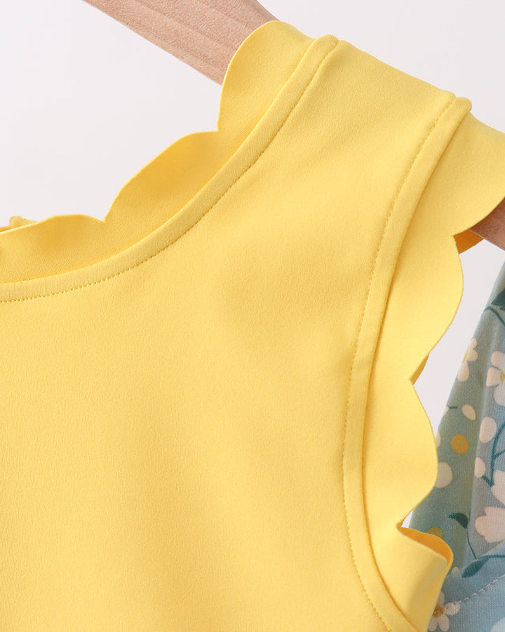 Yellow sleeveless top with ruffled details on a white background