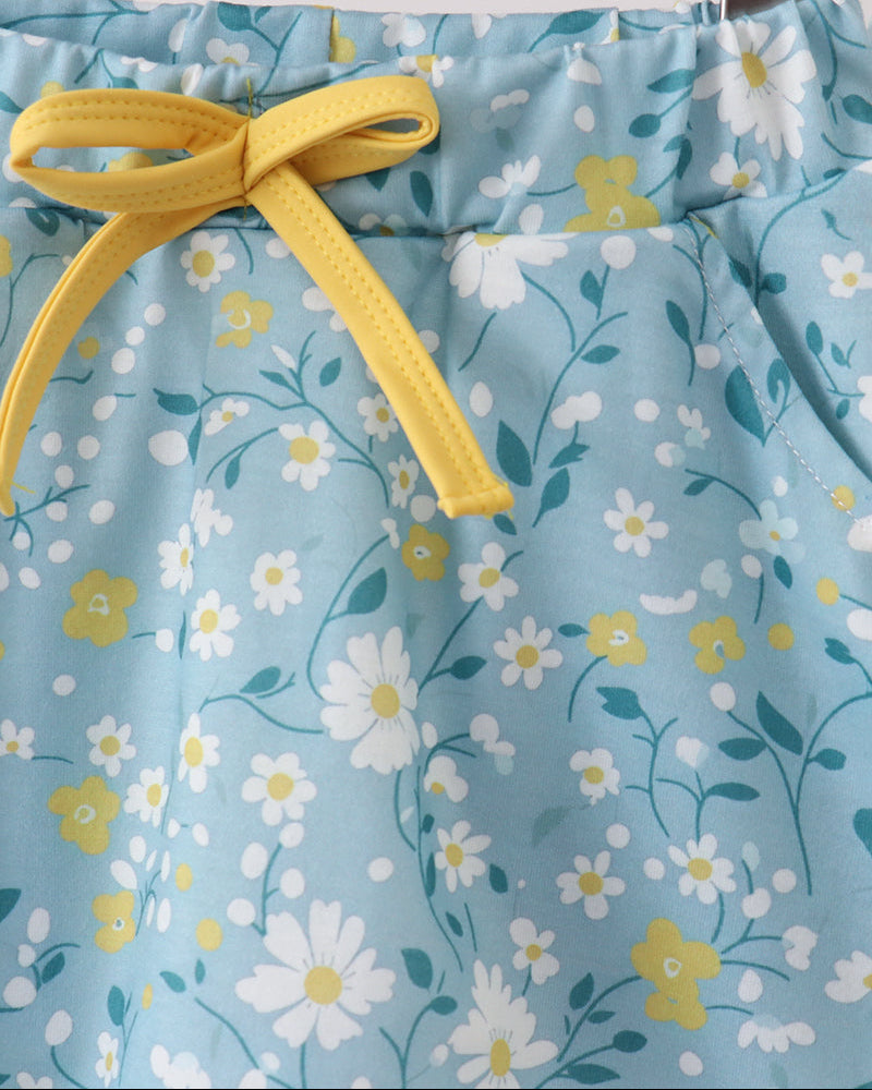 Floral-patterned skorts with a yellow drawstring on a wooden background