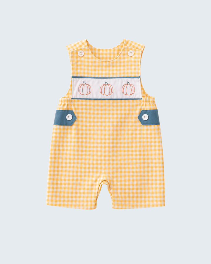 A baby romper in a yellow and white gingham pattern, featuring a decorative chest panel with three embroidered orange pumpkins, blue buttoned flap pockets, and snap closures at the shoulder.