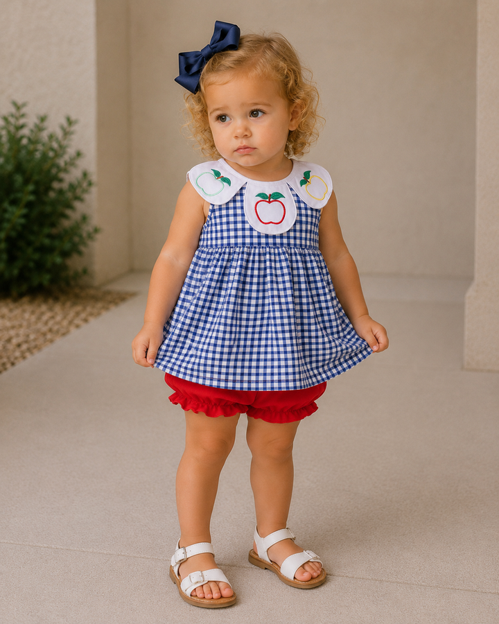 Toddler girl is standing outside holding on to her dress.