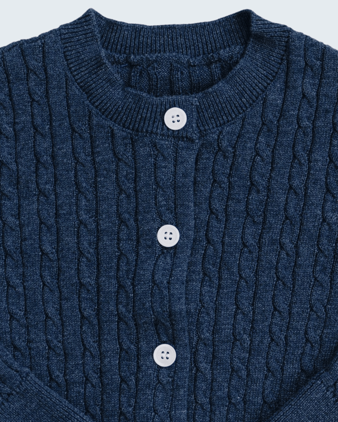 Close-up of a navy blue cable-knit cardigan sweater with a ribbed crew neck and three white buttons.