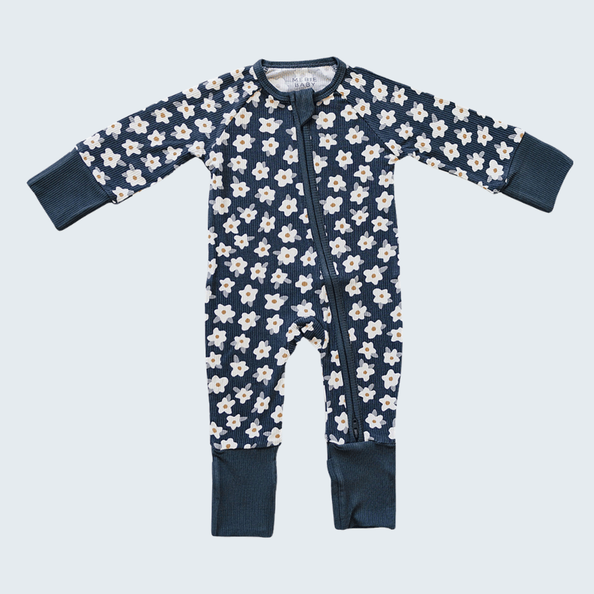Navy baby onesie with white floral pattern on a light blue background