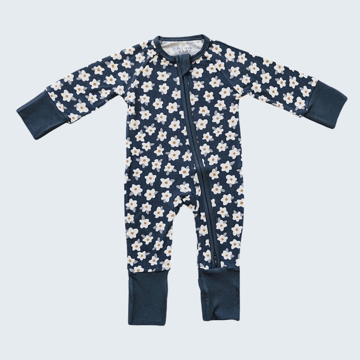 Navy baby onesie with white floral pattern on a light blue background