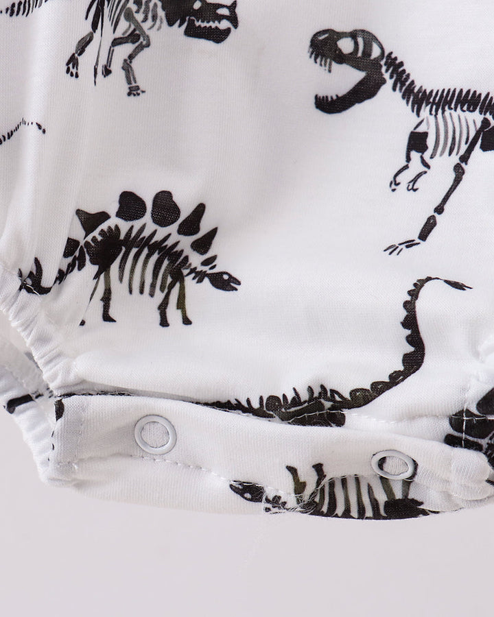 White baby romper with black dinosaur skeletons on a white background