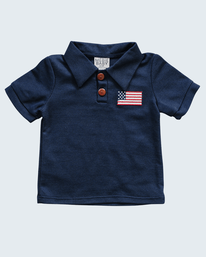 Navy blue polo shirt with American flag patch and brown buttons on a light gray background