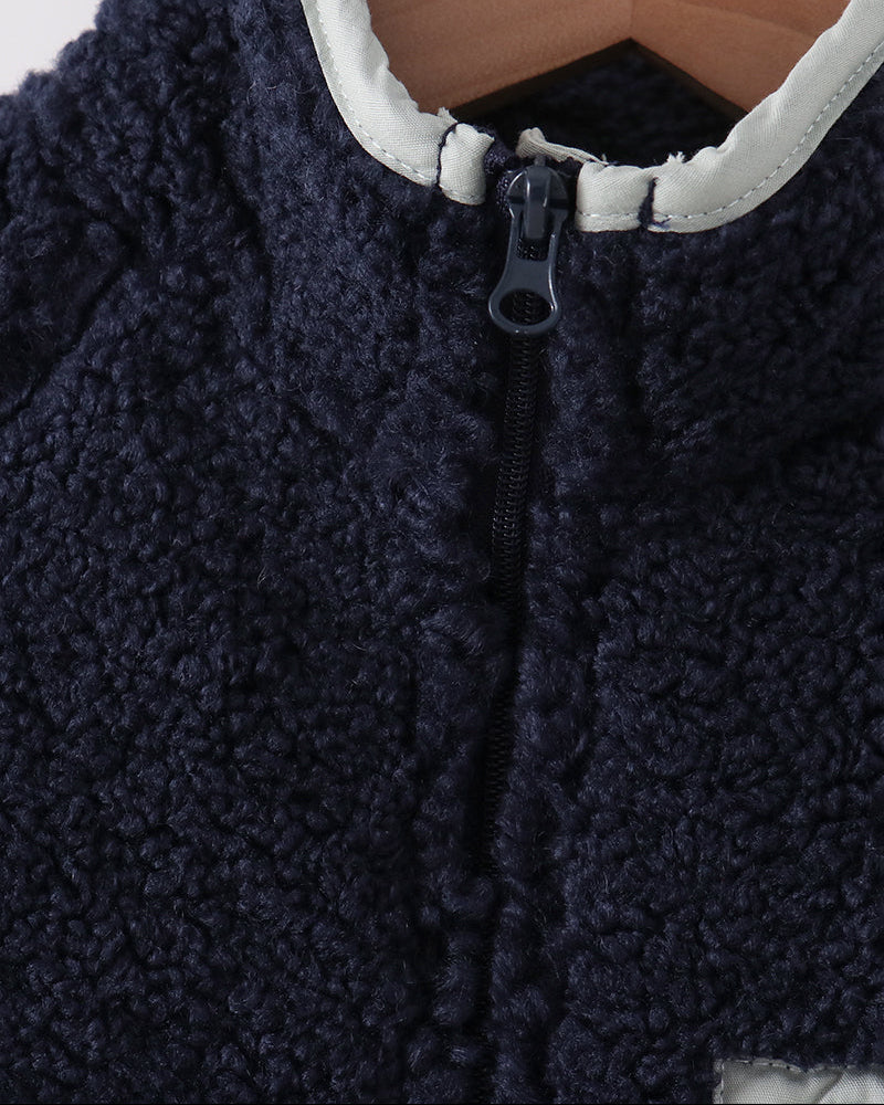 Navy fleece jacket close-up of stand collar and front zipper with pull tab