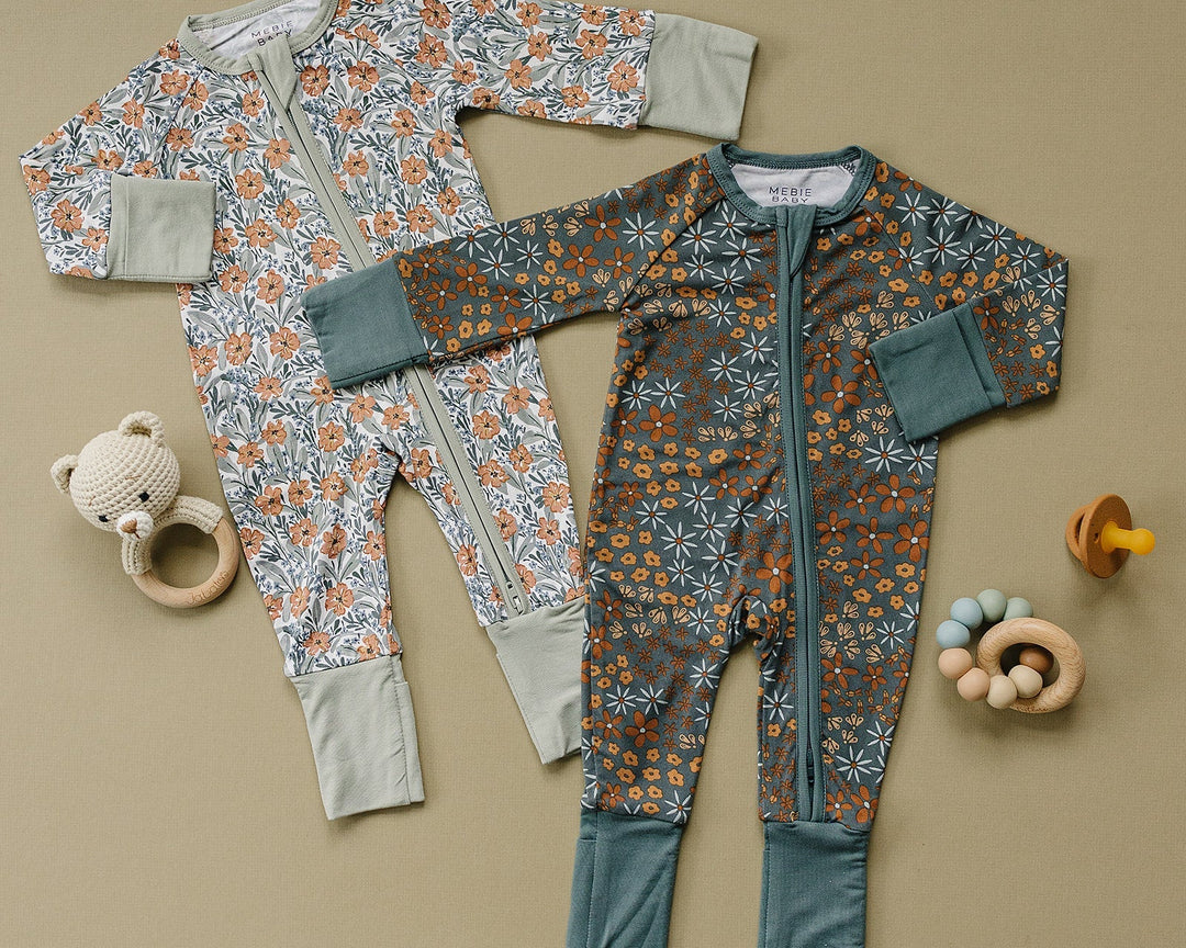 Two baby rompers with floral patterns on a beige background