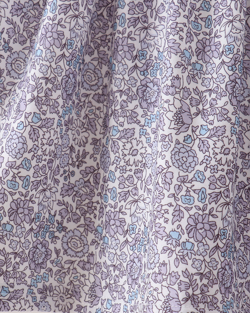 A close-up of a white fabric with an all-over floral print in lavender purple and light blue, showing the material&