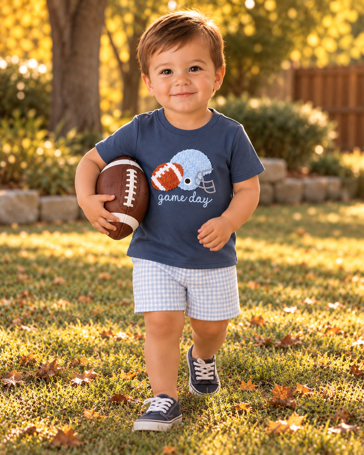 Toddler boy wearing navy football T-shirt and light blue gingham shorts