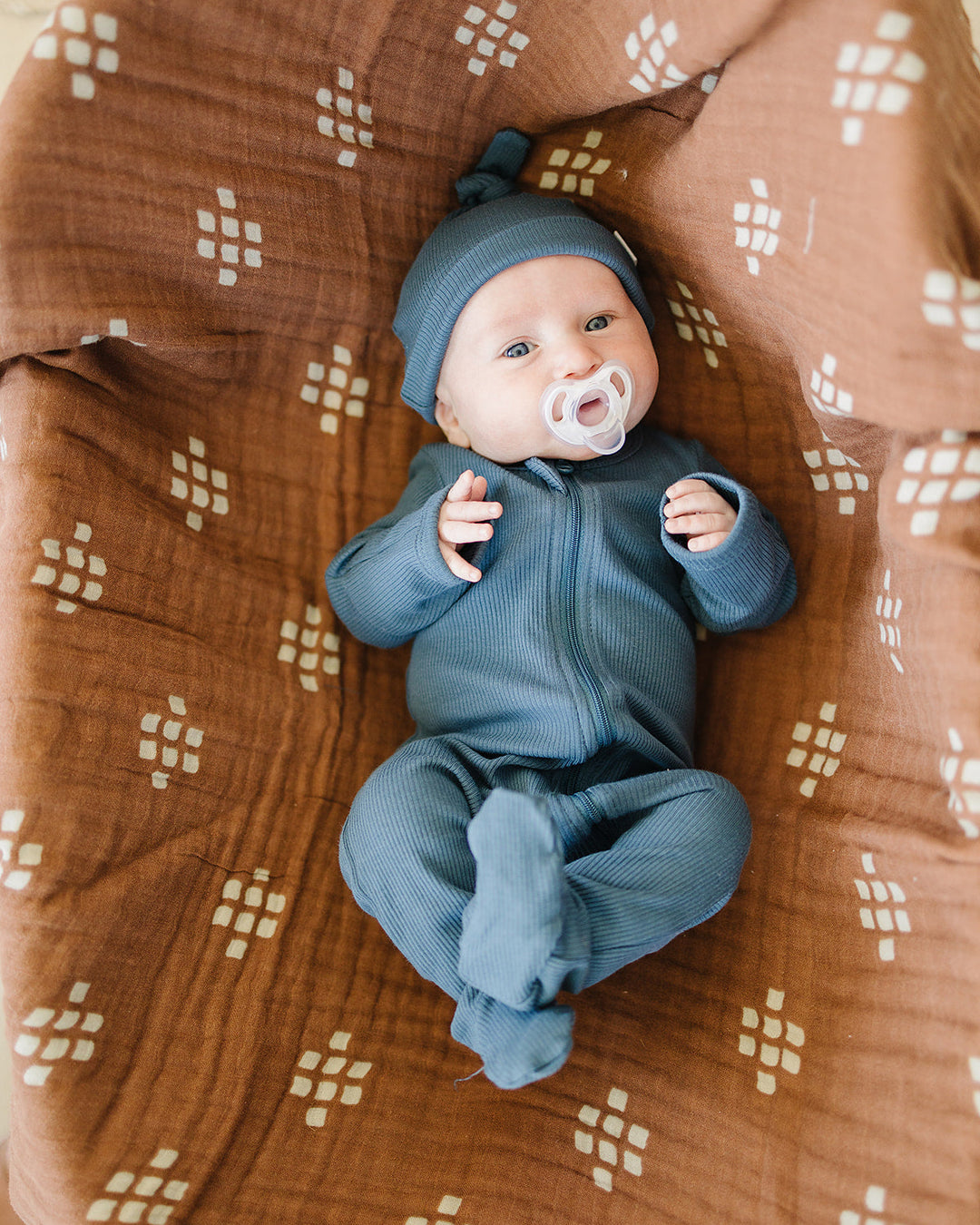 Dark blue ribbed zip-front footed baby onesie with long sleeves