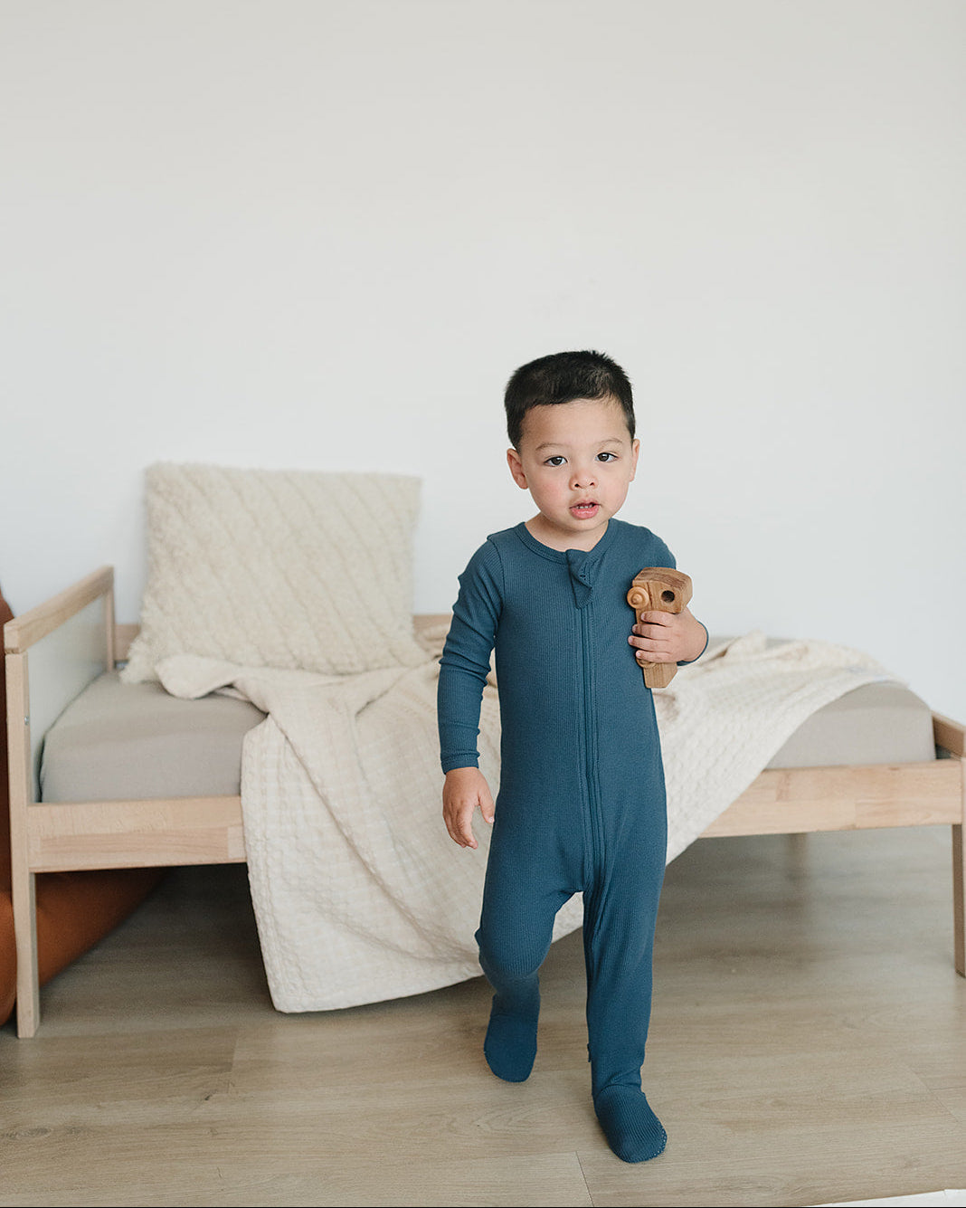 Dark blue ribbed zip-front footed onesie, long sleeves; full-body on child