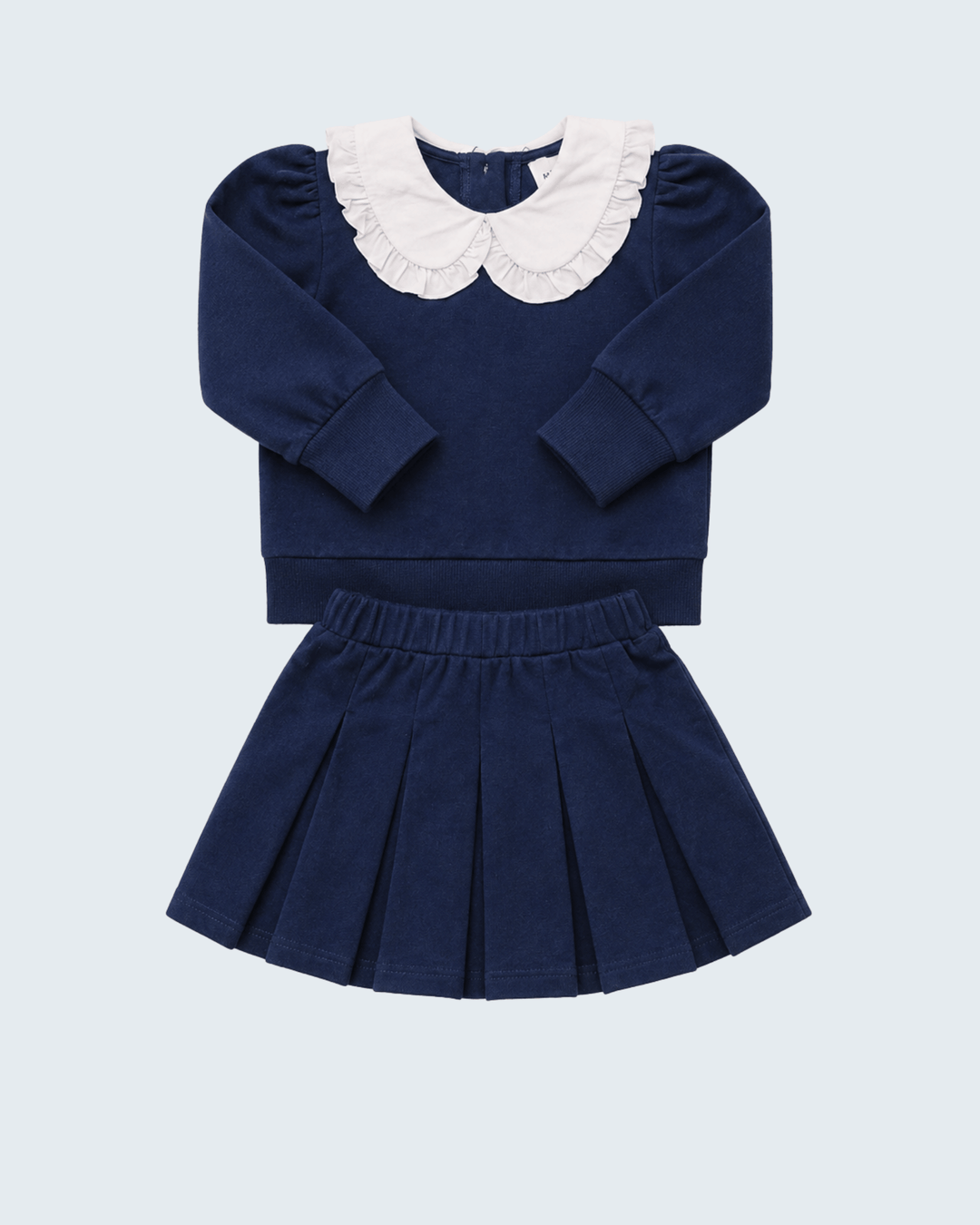 Navy long-sleeve knit top with white Peter Pan collar and navy pleated skirt