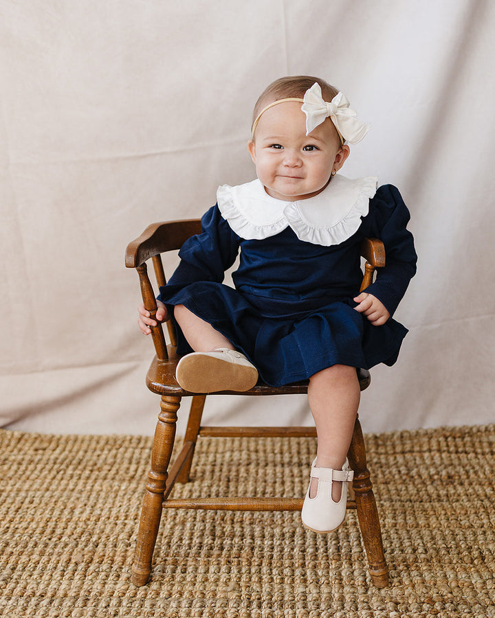Navy skirt set on baby with long sleeves, white ruffled Peter Pan collar