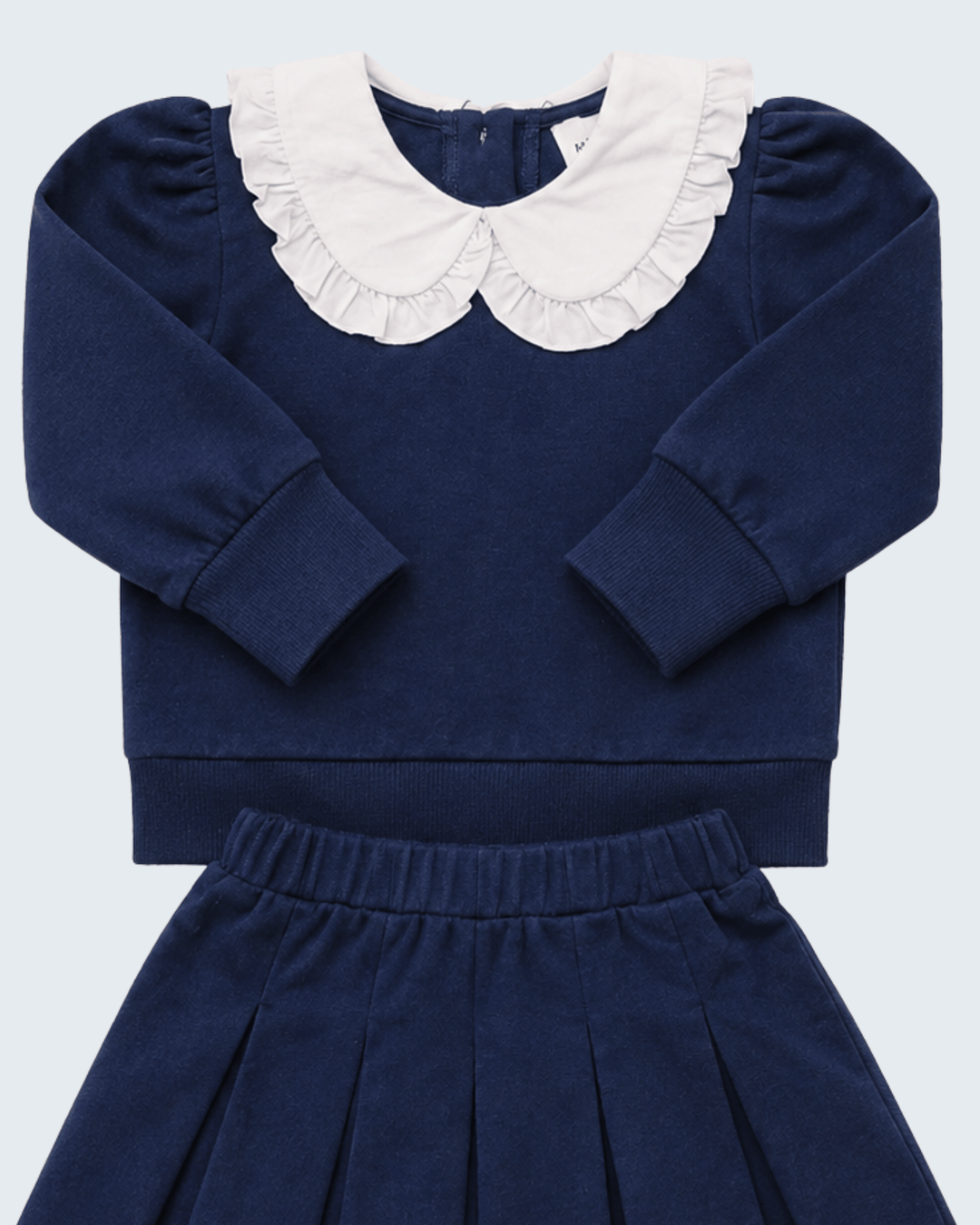 Navy knit set with white ruffled Peter Pan collar, long sleeves, and pleated skirt