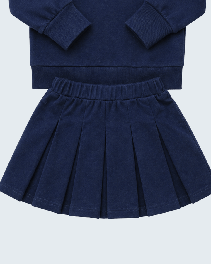 Navy pleated skirt with elastic waistband paired with matching navy long-sleeve top