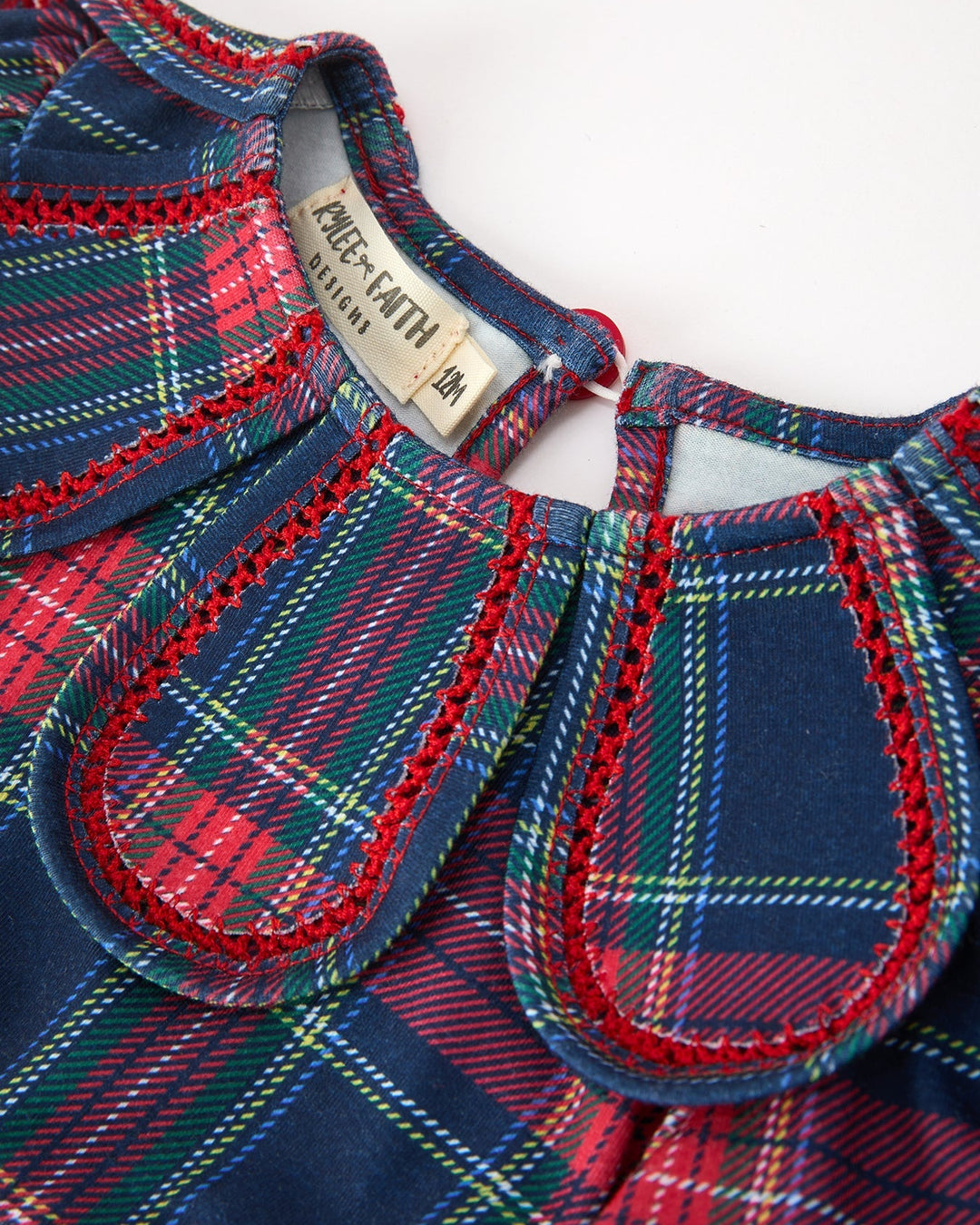 Plaid dress neckline closeup with petal collar, trim stitching, and size tag