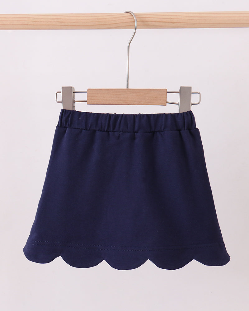 Navy scalloped hem skort with elastic waist, hanging on a hanger