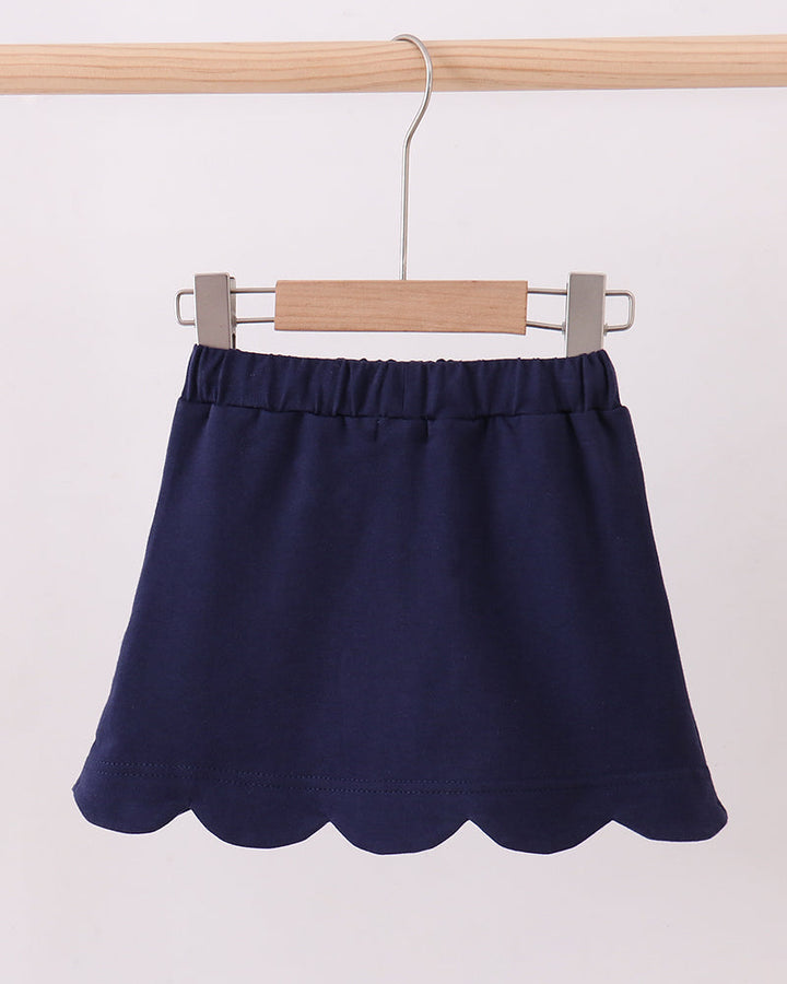 Navy scalloped hem skort with elastic waist, hanging on a hanger