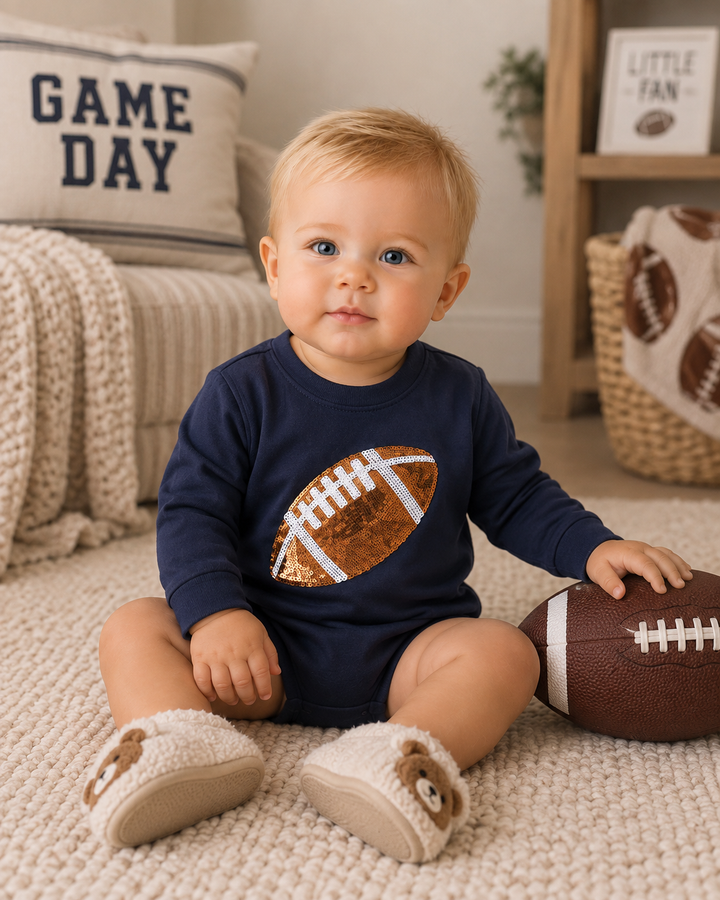Navy long-sleeve baby bodysuit with sequined football front, worn by toddler