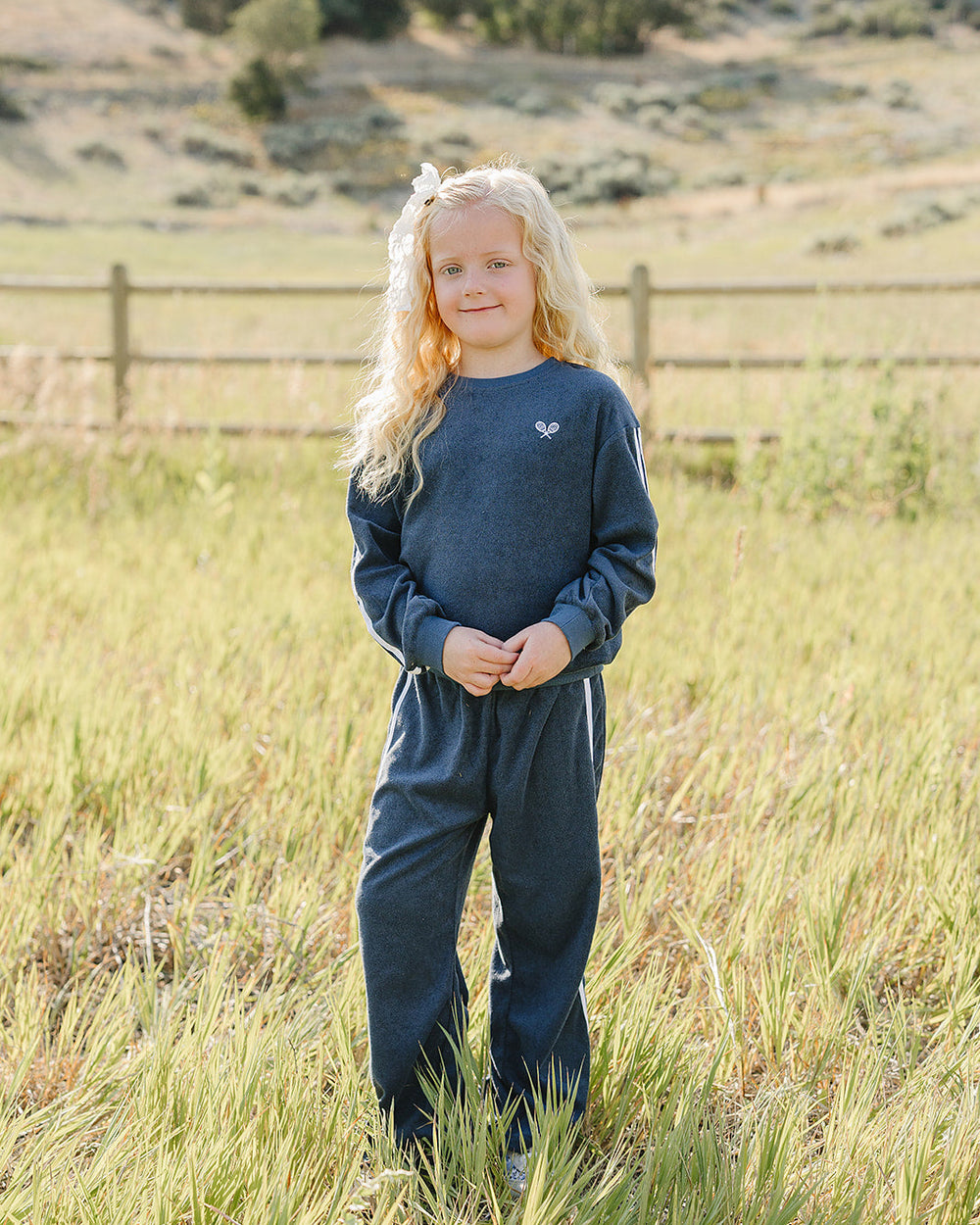 Navy terry tracksuit with crew sweatshirt and jogger-style pants, white stripe accents