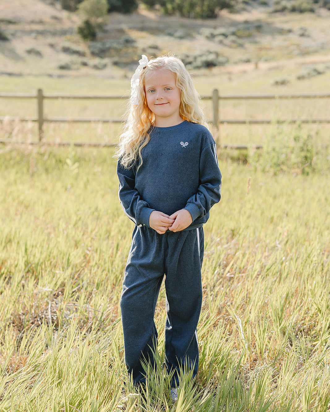 Navy terry tracksuit with crew sweatshirt and jogger-style pants, white stripe accents