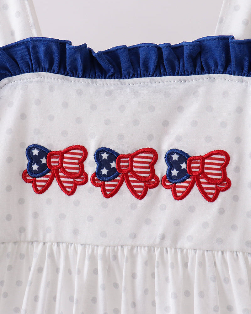 White dress with blue ruffled neckline and red, white, and blue bow designs.