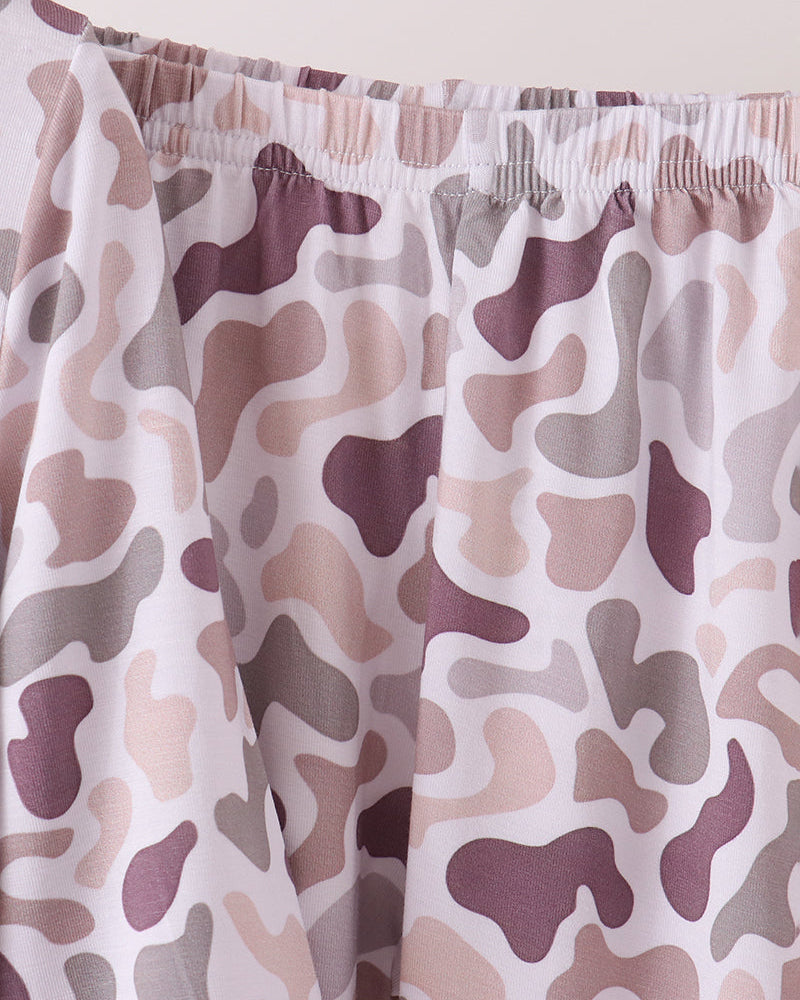 Close-up of a pair of PJ bottoms with an elastic waistband, featuring a camouflage pattern in dusty purple, beige, and gray on a white base.