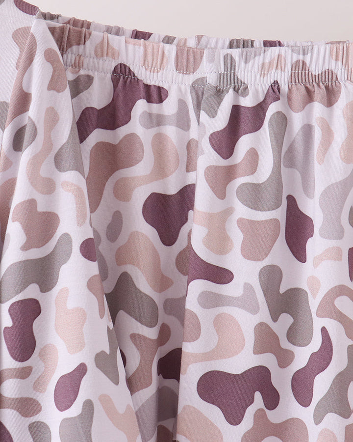 Close-up of a pair of PJ bottoms with an elastic waistband, featuring a camouflage pattern in dusty purple, beige, and gray on a white base.