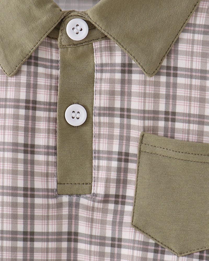 Close-up of a collared shirt with an olive green collar and placket, featuring two white buttons and an olive green chest pocket over a beige and brown plaid fabric.