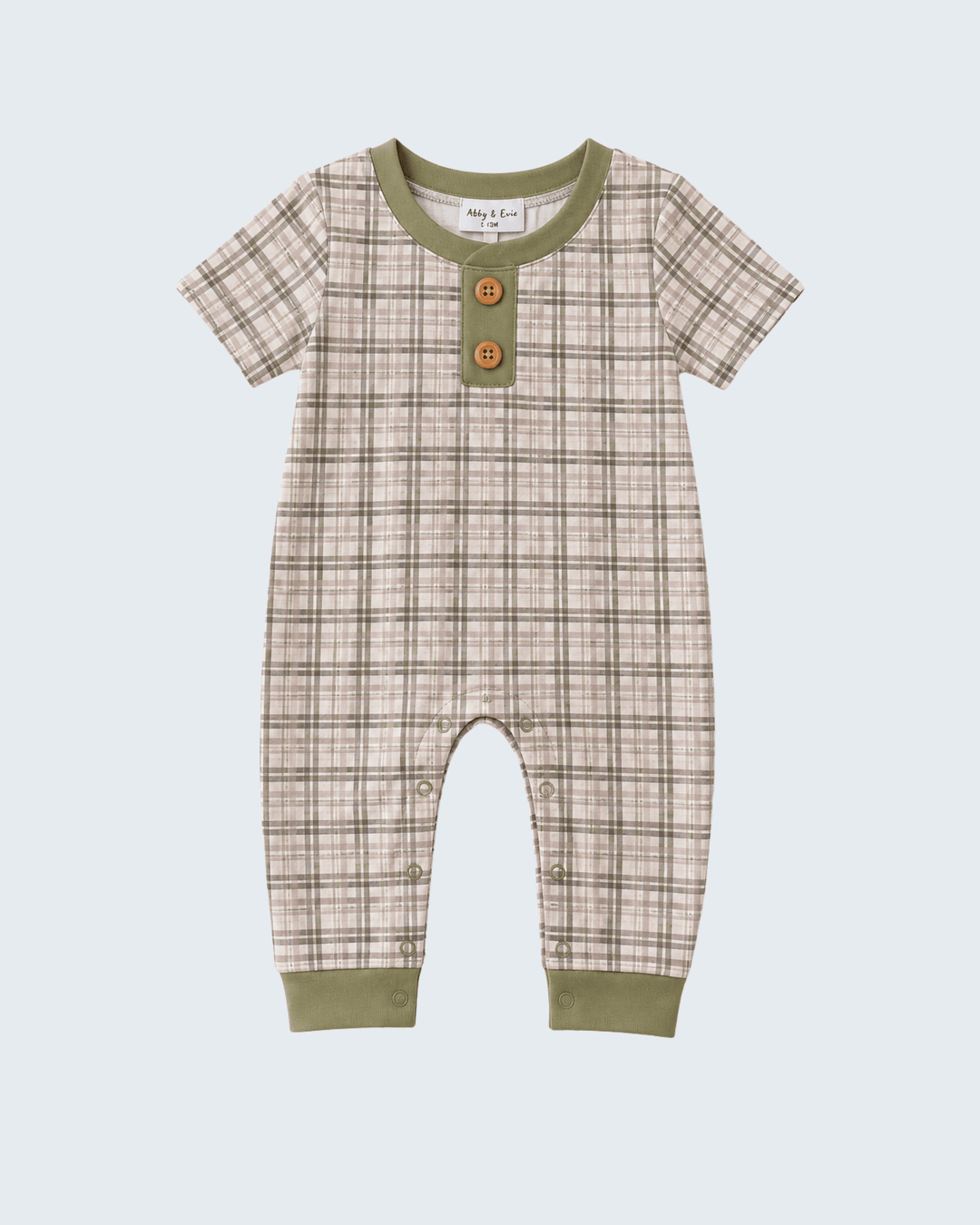 A baby short-sleeve romper in a beige and brown plaid pattern with olive green trim at the collar, cuffs, and hem, featuring two decorative wooden buttons on the chest.